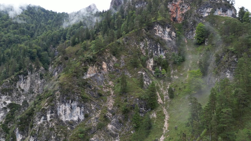 Mist clinging to wooded mountainside Bavaria Germany Drone Aerial view