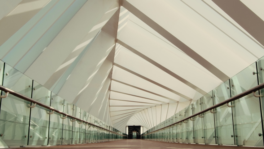 Pedestrian contemporary walkway covered metallic city crosswalk. Zoom out shot of futuristic interior of pedestrian glass, arches, wood and metal footbridge, overpass tunnel - Powered by Shutterstock - Get 15% off with code: PIKWIZARD15