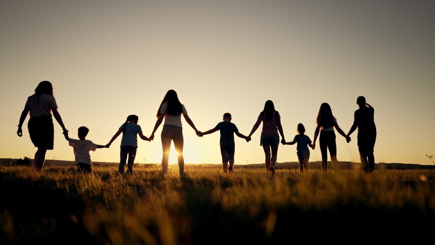 Big happy family. Group of people have fun walking in the park on green grass. Parents and children walk together holding hands at sunset. Family love and support. Family teamwork in park on vacation Royalty-Free Stock Footage #1095915825