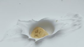 Sweet yellow banana pieces dropped into fresh natural yogurt in super slow motion close up. Sweet tasty fruit falling in creamy dairy dessert with splashes. Cooking delicious dessert for breakfast. - Powered by Shutterstock - Get 15% off with code: PIKWIZARD15