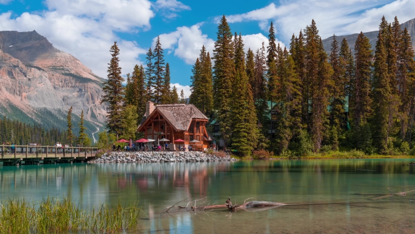 4K time-lapse UHD video of scenery of wooden house with rocky mountains and cloudy blowing reflection on Emerald Lake,a Glacial Lake at Yoho national park in the mountain parks of the Canadian Rocky