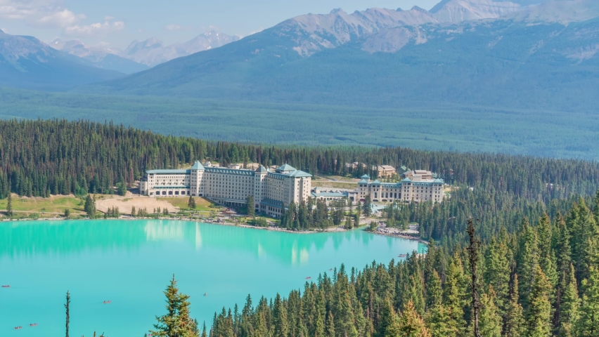 4K time-lapse UHD video of beautiful panoramic view of Lake Louise, a glacier mountain lake in Banff National Park, and Fairmont Chateau Hotel from a side view on a sunny summer day, Alberta, Canada Royalty-Free Stock Footage #1095926989
