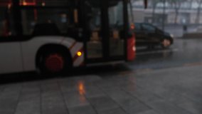 Blurry video. The movement of the car with the headlights on in the rain in the city. Raindrops fall on the pavement.
