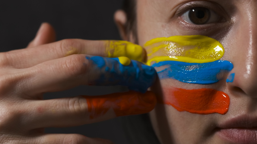 Supporter Painting Face and Looking at Camera. Football Fan Preparing for the Match. Colored Face with Flag Colors Yellow, Blue and Red. Slow Motion 4K Prores 422 | Shutterstock HD Video #1095933377