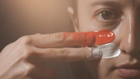 Supporter Painting Face and Looking at Camera. Football Fan Preparing for the Match. Colored Face with Flag Colors Red and White. Slow Motion 4K Prores 422 - Powered by Shutterstock - Get 15% off with code: PIKWIZARD15