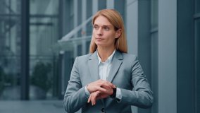 Serious sad businesswoman standing outdoors looking around waiting for business meeting impatient woman dissatisfied looks at wristwatch checks time on watch annoyed by being late lateness concept - Powered by Shutterstock - Get 15% off with code: PIKWIZARD15
