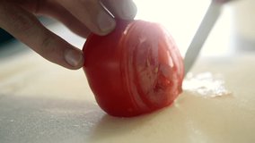 A sharp handcrafted Japanese Knife , slicing cleanly through a fresh tomato and other vegetables, skilled chef, slow video show casing a sharp Japanese knife 