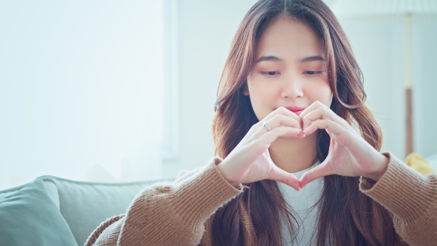 Close up of happy young asian woman smiling and showing hands sign heart shape looking at camera. Healthy heart health life insurance, love and charity, voluntary social work. Royalty-Free Stock Footage #1095948193