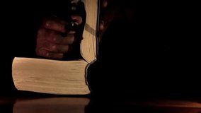 man praying to god with hands together with bible Caribbean man praying with black background stock video