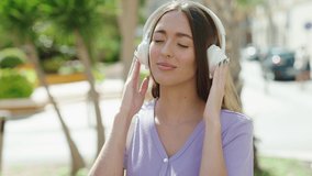 Young beautiful hispanic woman smiling confident listening to music and dancing at street - Powered by Shutterstock - Get 15% off with code: PIKWIZARD15