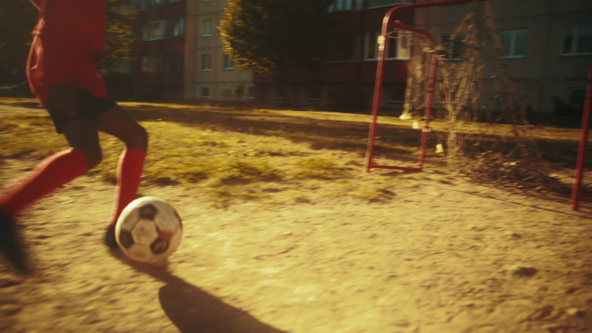 Young African Kid Playing with Ball in the Neighborhood. Young Black Boy Practicing Soccer Drills, Scoring a Goal. Teenager Dreaming of Becoming a Professional Football Player. Royalty-Free Stock Footage #1095954861