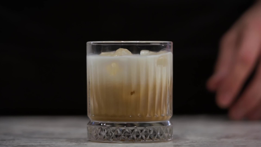 Preparation of a white Russian cocktail. Cocktail mixing. The bartender prepares a cocktail. Royalty-Free Stock Footage #1095958031