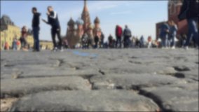 Blurred video of tourists walking on Red Square. Close-up Red Square pavings. Moscow landmarks: Saint Basil's Cathedral and Kremlin. Crowd of people on Red Square.