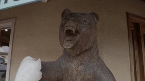 This video shows a large, hand carved wooden bear statue with bubble wrapped paws.