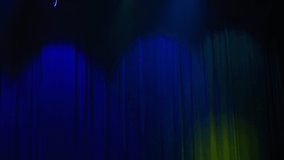 Blue velvet curtain with multicolored spotlights in theatre during performance. Abstract motion backgrounds for music videos
