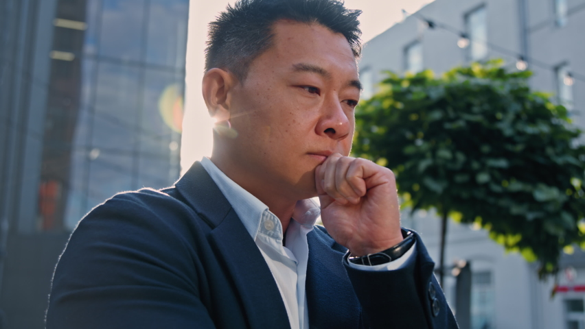 Side view pensive Asian Korean man thinking about business idea. Adult 40s middle-aged Chinese businessman thoughtful entrepreneur employer in city think solving problem pondering looking at camera Royalty-Free Stock Footage #1095971511