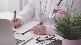 working doctor hands in white coat writing notes filling medical forms using pen and clipboard laptop data information clinical office room. concept medical occupation workplace working day of doctor