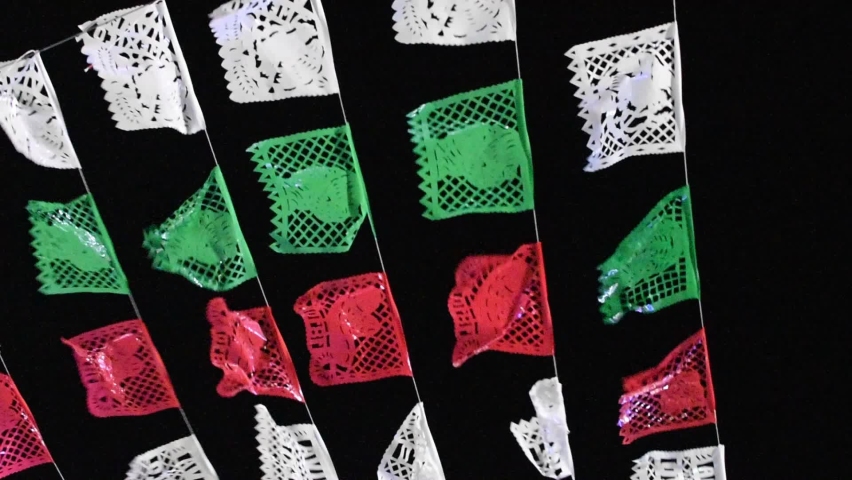 Banners of chopped paper. with the colors of the Mexican flag waving in the wind in the dark- pan left. Royalty-Free Stock Footage #1095975091