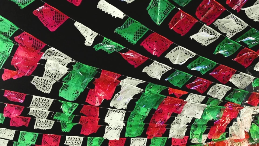 Banners of chopped paper. with the colors of the Mexican flag waving in the wind in the dark- pan right. Royalty-Free Stock Footage #1095975097