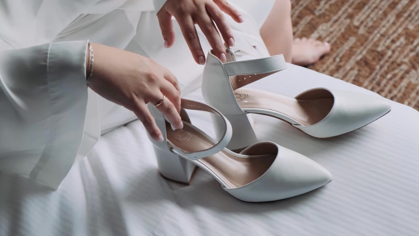 female hands take white shoes
