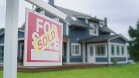 Close Up of a House Sold Sign on a Lawn in Front of a Big Modern House with Traditional Architecture. Housing Market Concept with Residential Property in the Countryside. - Powered by Shutterstock - Get 15% off with code: PIKWIZARD15