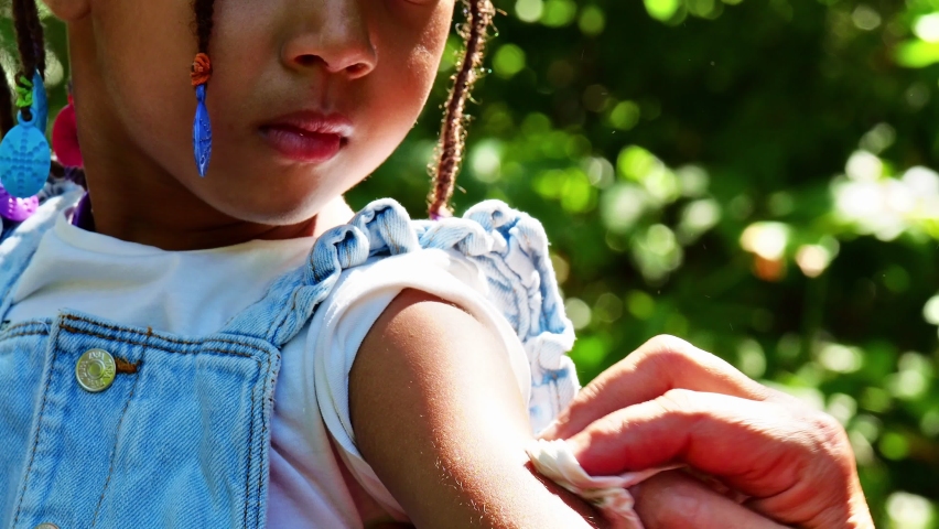 little kid in the farm wearing denim salopette caring the growth of veggies