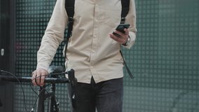 Young man walking on the street whit a bicycle and using phone. - Powered by Shutterstock - Get 15% off with code: PIKWIZARD15
