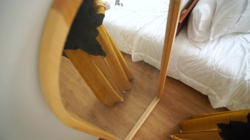 Woman is looking in the mirror before going out of the house