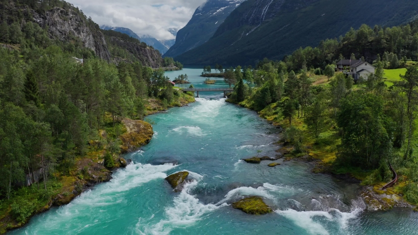 Lake bottom Loenvatnet with glacial river starting to flow dowm Lodalen valley - moving aerial