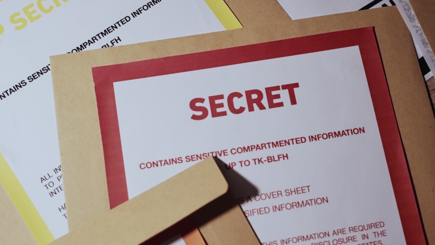 Top shot various types of classified information with color codes and warnings. Red, Orange and Blue for secret, top secret and confidential files and papers. Leaked or exposed sensitive material Royalty-Free Stock Footage #1096006925