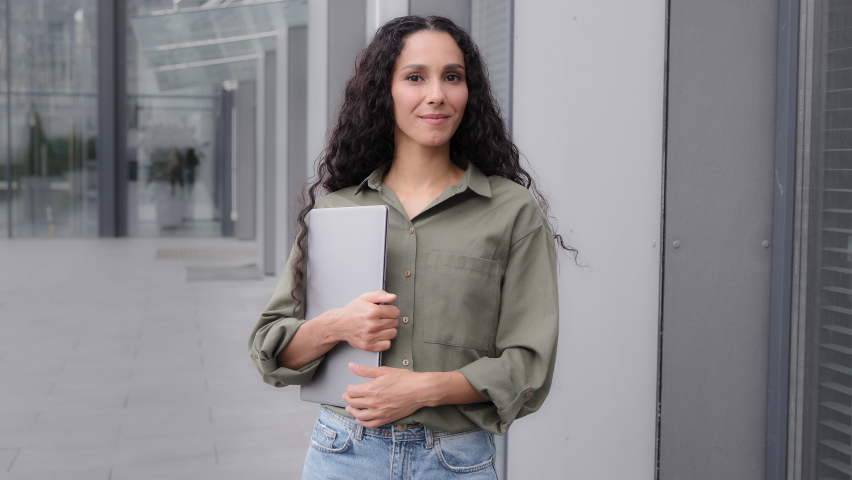 Smiling Latina Caucasian Hispanic 30s woman with laptop businesswoman teacher HR manager recruiter outdoors in city welcome invite wave hand come on go here welcoming motivated to join invitation Royalty-Free Stock Footage #1096008021