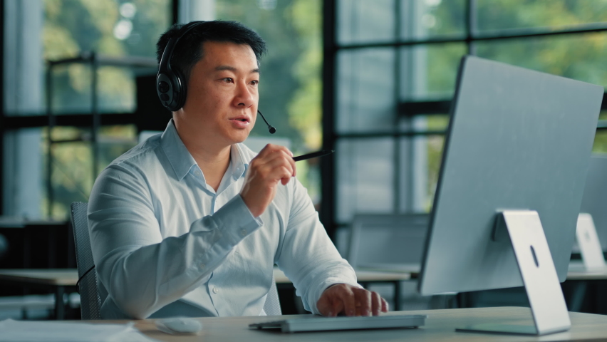 Professional consultant business coach businessman educator teacher asian korean man use headphones talk online with colleagues by video chat distant work conference in office telemarketing profession