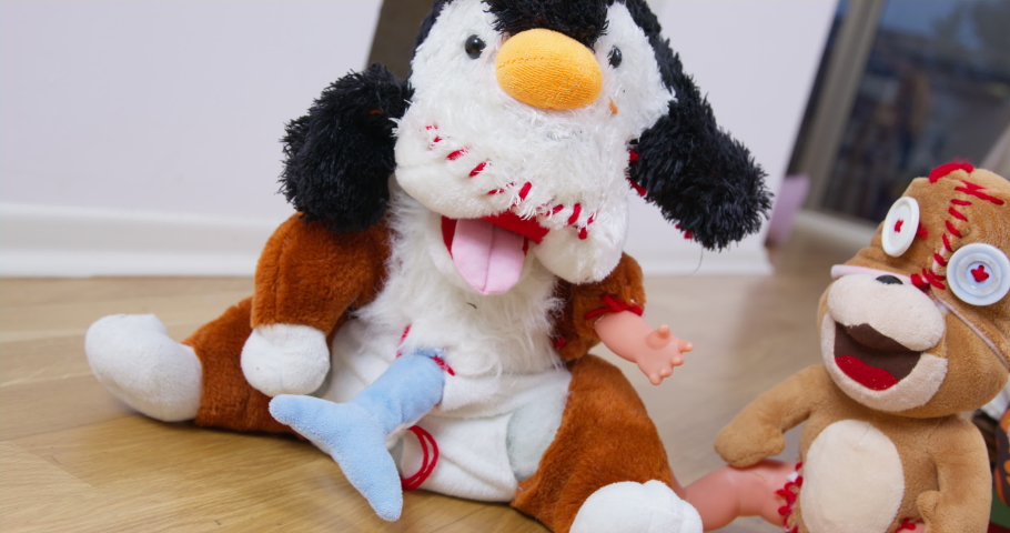 Soft toys standing on the wooden floor, which incorrectly sewed limbs and roughly sewed holes with a large thread, so they look creepy now, front view, Dutch angle Royalty-Free Stock Footage #1096012671