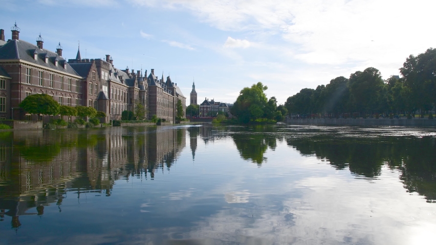 Hofvijver reflection, the Dutch parliament building with Den Haag city scape in the background and the winds blowing the pond surface creating waves under a beautiful sunny spring, Netherlands