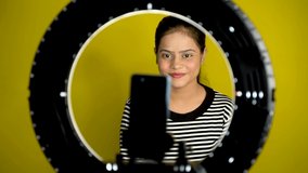 Beautiful young Asian vlogger or blogger making video with ring light and smartphone. Social media or Internet influencer people or content creator.