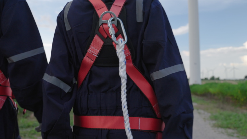 Two maintenance engineers in safety gear working at height walking to the wind turbine to check the operation of the wind turbine, clean energy concept, renewable energy, save the world,reducing co2,  Royalty-Free Stock Footage #1096022281