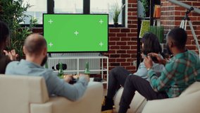 Group of people using greenscreen template to play video games, having fun gaming on isolated chroma key background. Playing online competition challenge on blank mockup copyspace.
