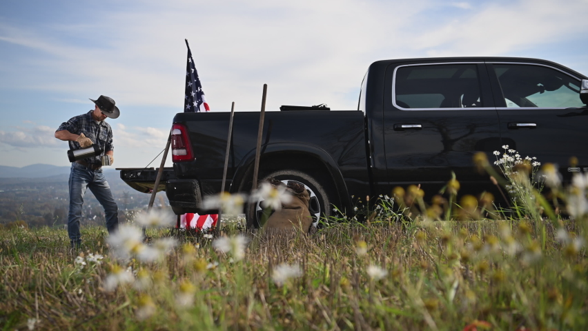 American Cowboy Staying on His Farmland and Drinking Coffee Next to His Truck