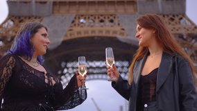 Medium shot of two young girls standing in centre of Paris on sunset, drinking champagne, communicating. Europe travel concept. Friends having fun near Eiffel Tower, clinking glasses. Slow motion - Powered by Shutterstock - Get 15% off with code: PIKWIZARD15
