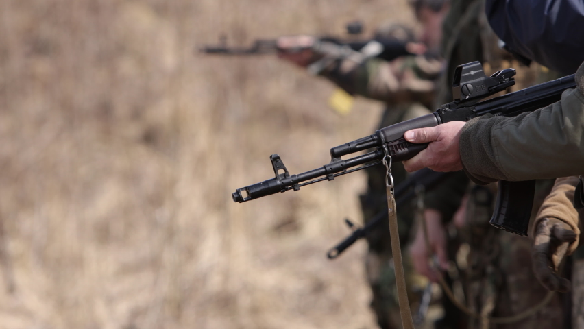 A machine gun is being used by a men on a shooting range in order to shoot at a target