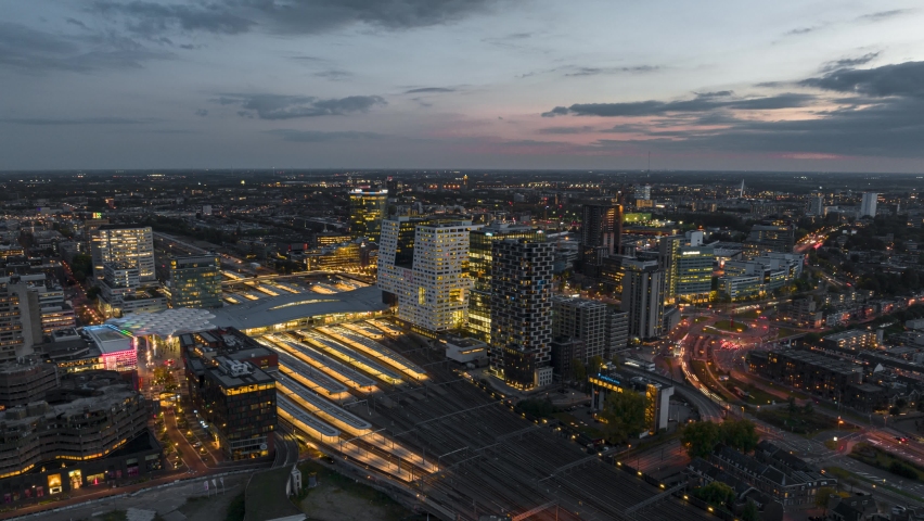 4k aerial time lapse of illuminated Utrecht central train station during rush hour with trains arriving and departing