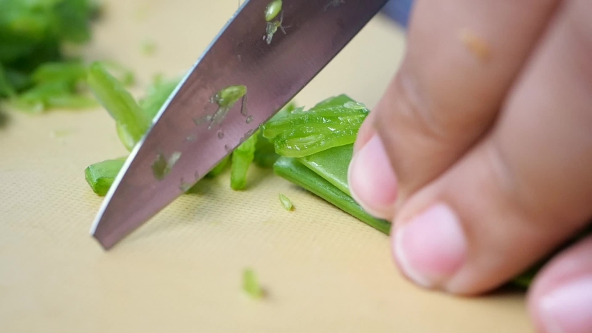 slow motion of women cutting Holland beans on the cutting board