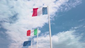 French, EU, and Italian flags waving in the wind. It is a beautiful sunny summer day, with blue sky and white clouds in the background. 4K stock video