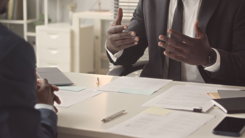 Cropped of unrecognizable Black man gesticulating while talking about his work experience and handing resume to employer during job interview in successful company, shaking hands in respect Royalty-Free Stock Footage #1096054229