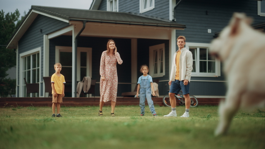 Family Spending Leisure Time Outside with Kids and a Pet Dog, Playing Ball with a White Golden Retriever. Happy Young Couple Playing Football with Daughter and Son on a Lawn in Their Front Yard.
