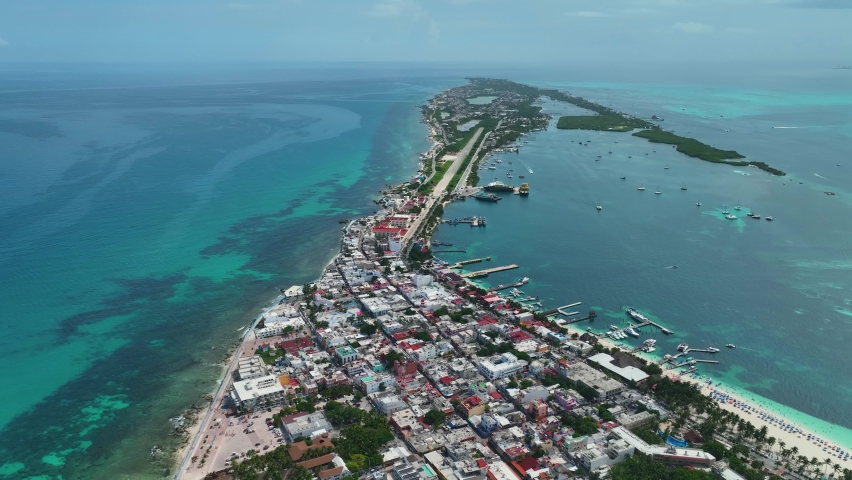 Aerial view over the town on the Isla Mujeres island in sunny Mexico - rising, pull back, drone shot