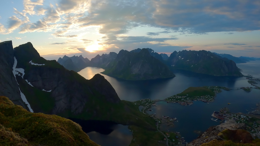 Beautiful time lapse from the summit of a mountain of clouds streaming by over peaks in the famous Reinebringen Hike during the midnight sun, Norway