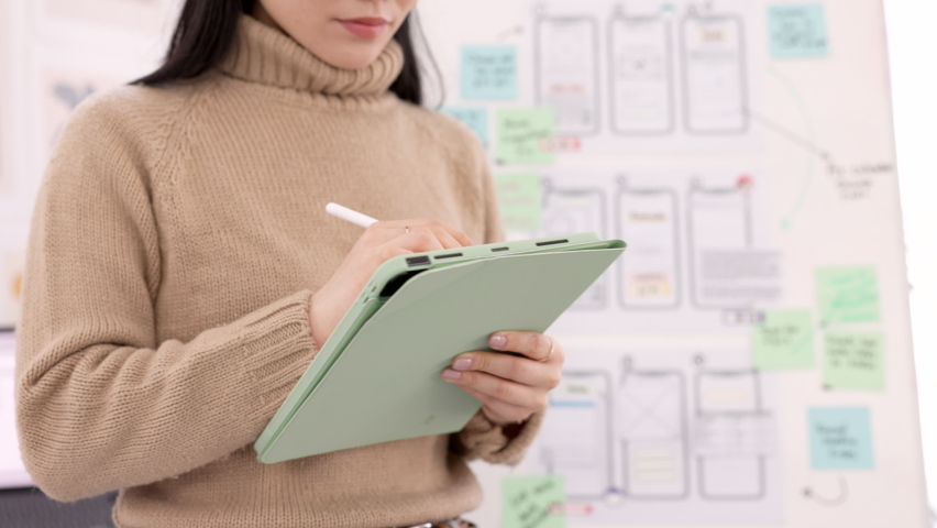 Woman, tablet and ui ux design with the developer being creative for mobile app project with a pen in office. Female planning, web design and development of wireframe on storyboard for website idea
