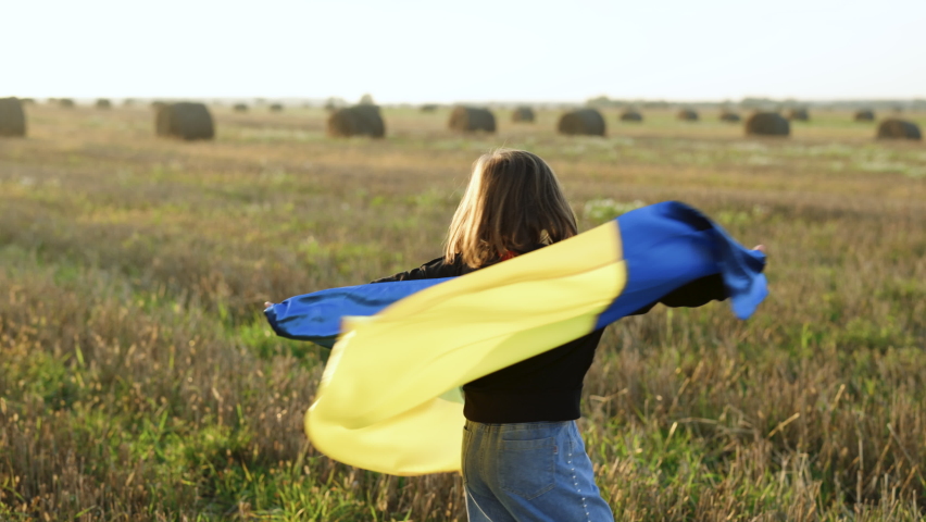 Portrait of Child with Ukrainian flag in field. Little girl waving national flag praying for peace. Happy kid celebrating Independence Day. Pray for Ukraine. Royalty-Free Stock Footage #1096073025
