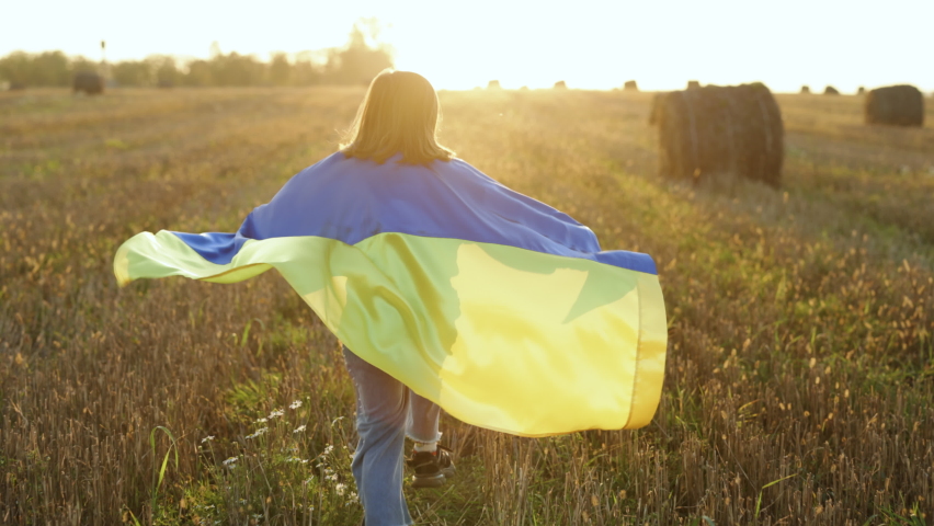 Cute little girl Ukrainian patriotic child runs with national flag of Ukraine showing political position. Stop war in Ukraine. Support, stand with Ukraine, Save, Help, Pray for Ukraine. Royalty-Free Stock Footage #1096073029